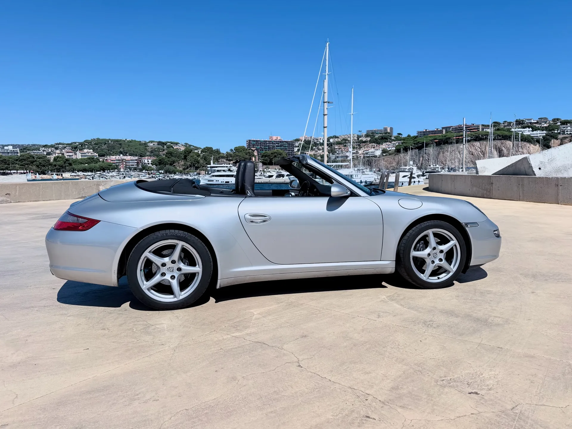 Complete side profile of the Porsche 911 Carrera 4 Cabriolet with the roof raised