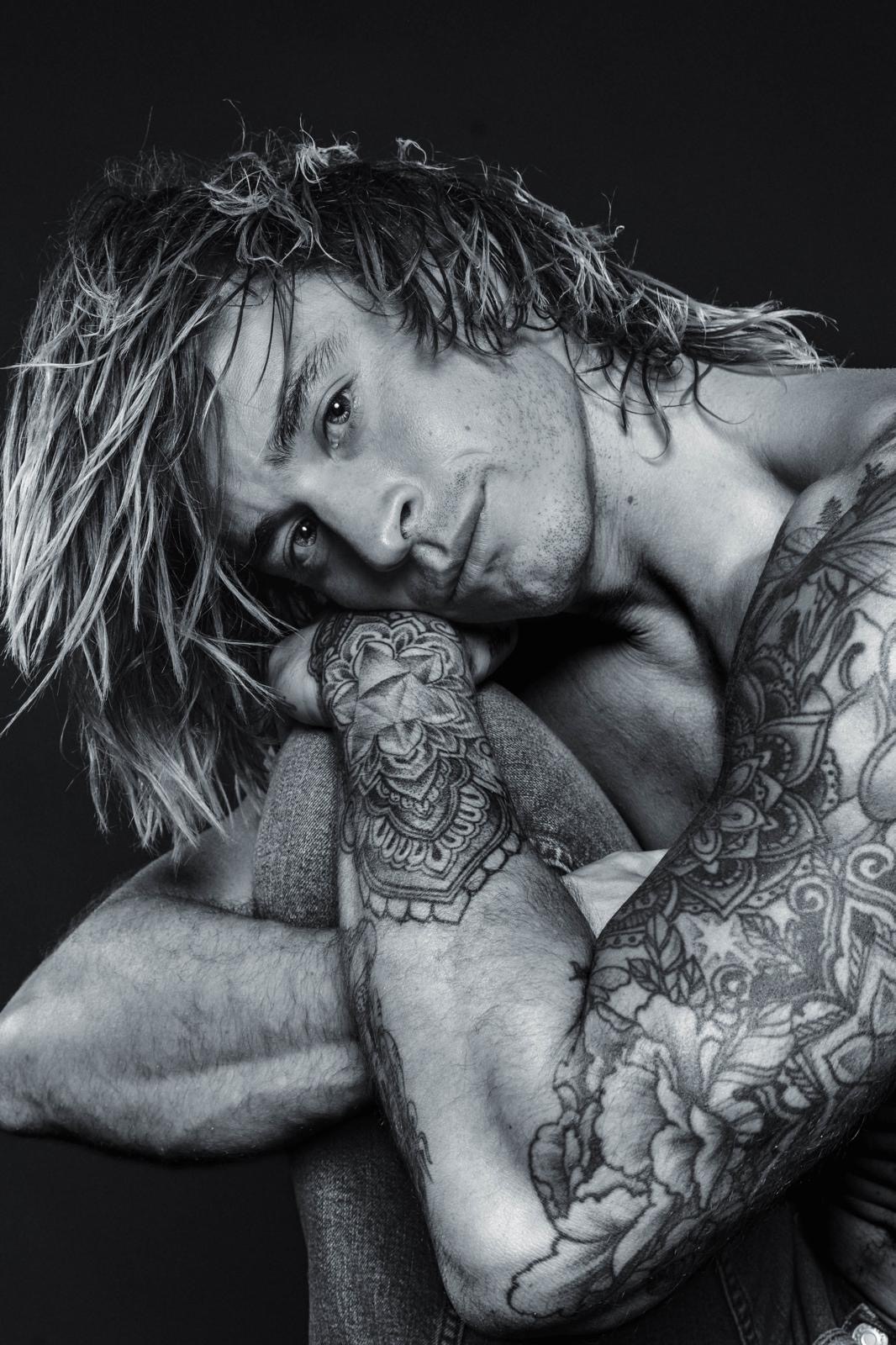 Black and white portrait with tattooed arms