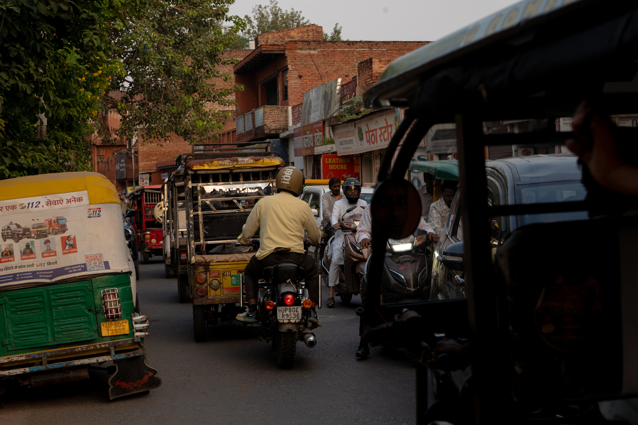 Busy Indian street with rickshaws, motorcycles, and chaotic traffic