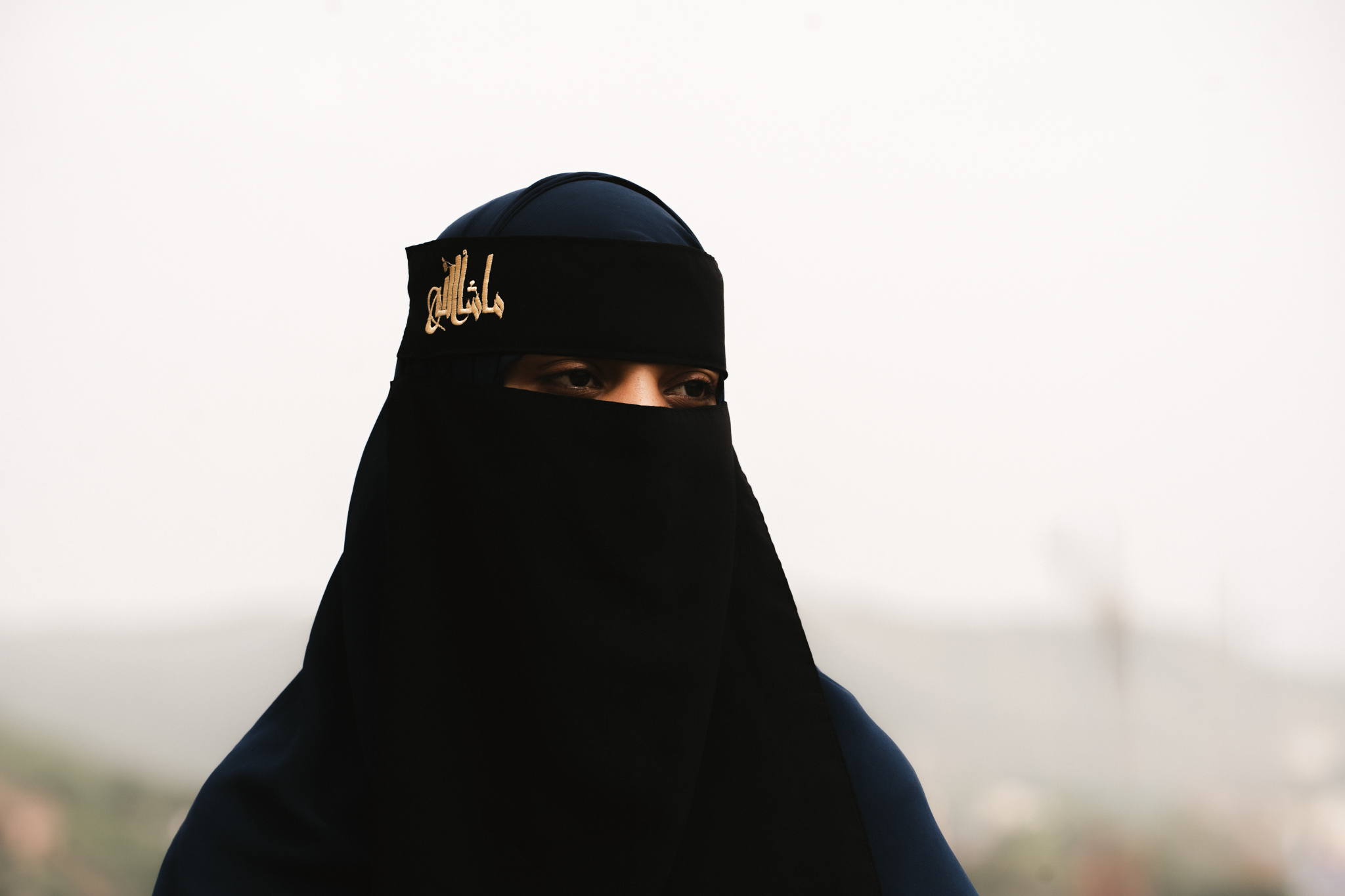 Portrait of woman in niqab with gold embroidery