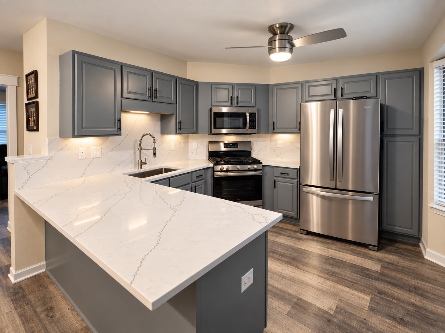 White veined quartz countertops paired with refinished slate-gray cabinets for a fresh, modern kitchen.