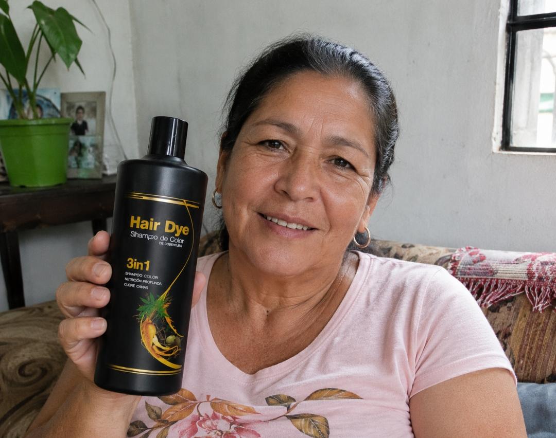 Daniela sonriendo en su sofá con el shampoo Hair Dye en la mano