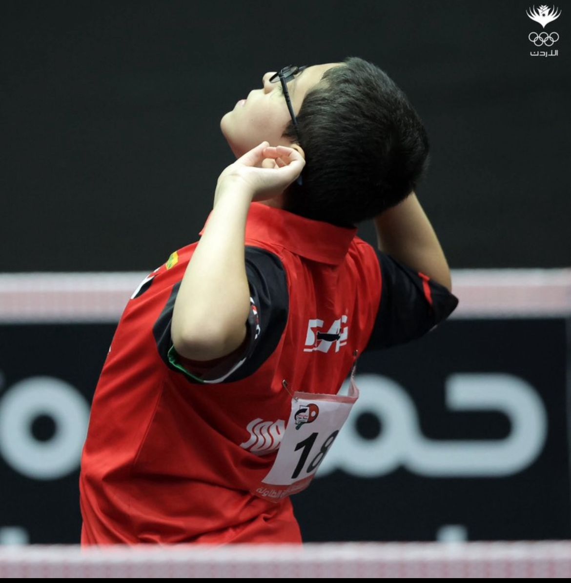 Rakan, Jordan's U15 table tennis champion, mid-rally in national team kit