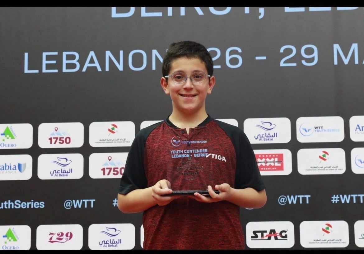 Rakan holding his WTT Youth Contender finalist trophy at the Lebanon Beirut event