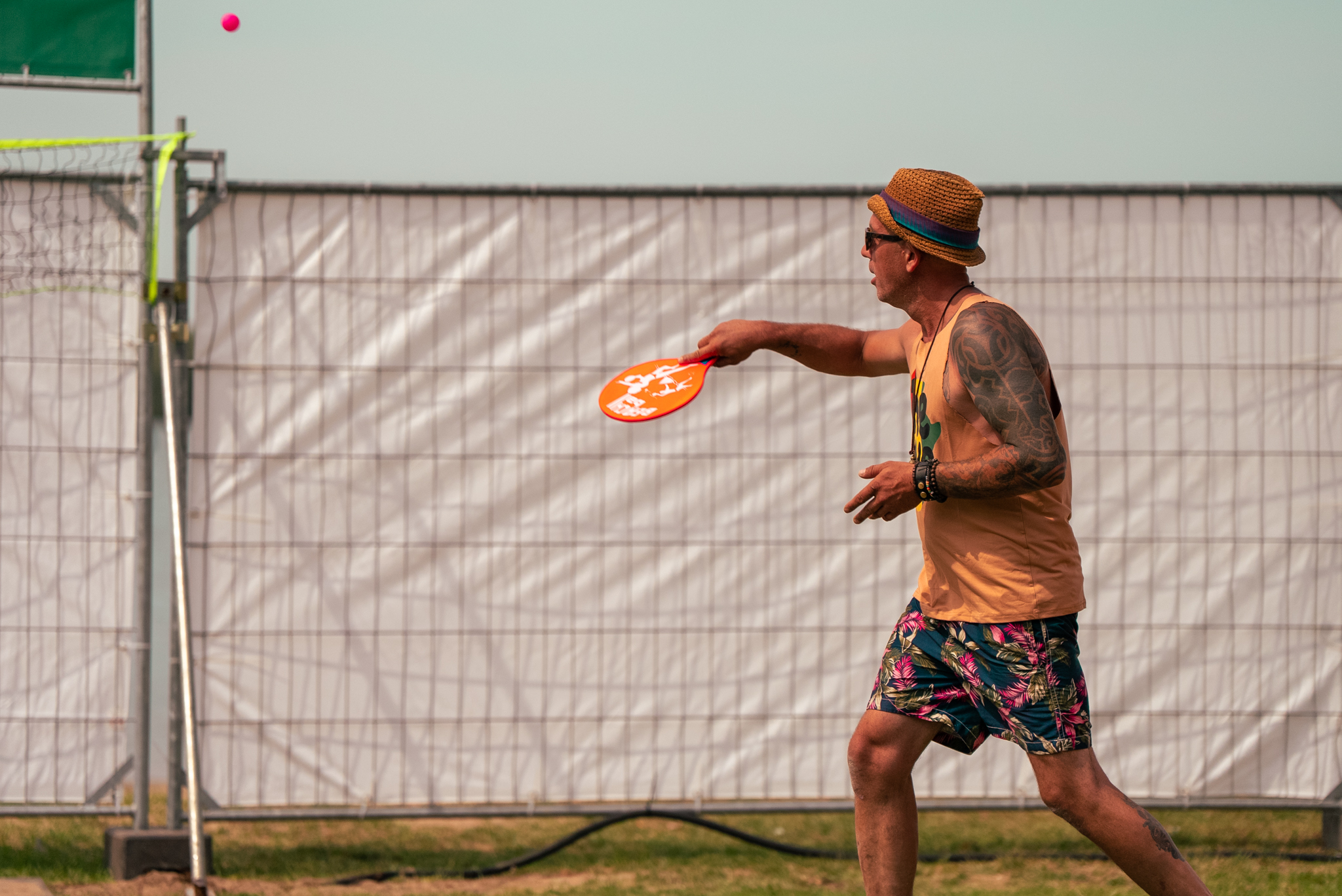 Man in rastapas speelt beachtennis op Rastaplas 2025