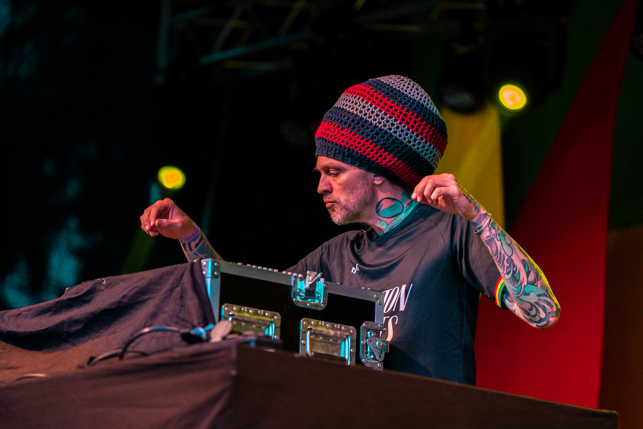 DJ met gebreide muts en tatoeages achter het podium bij Rastaplas 2025