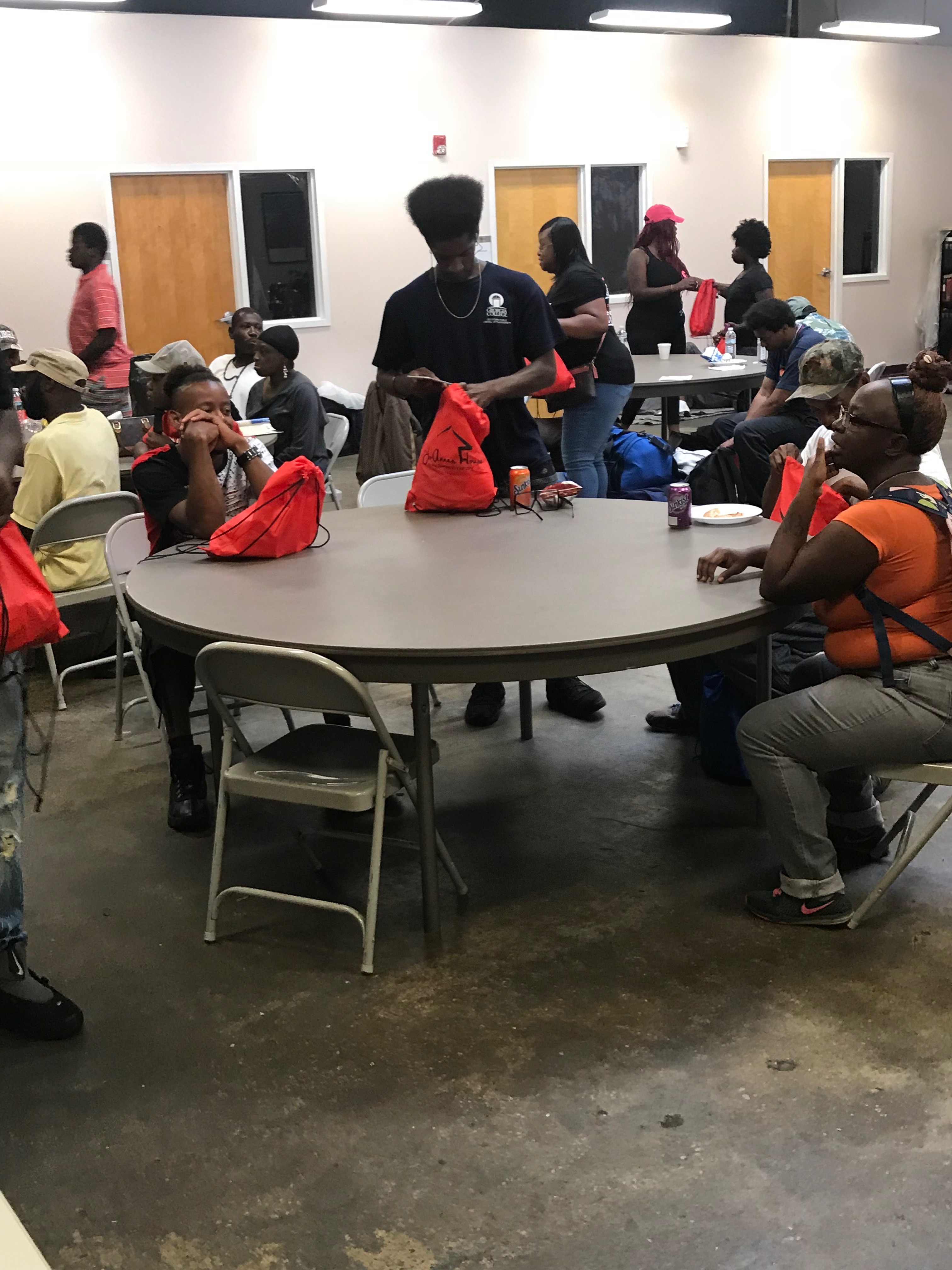 Volunteers distributing bags to community members indoors