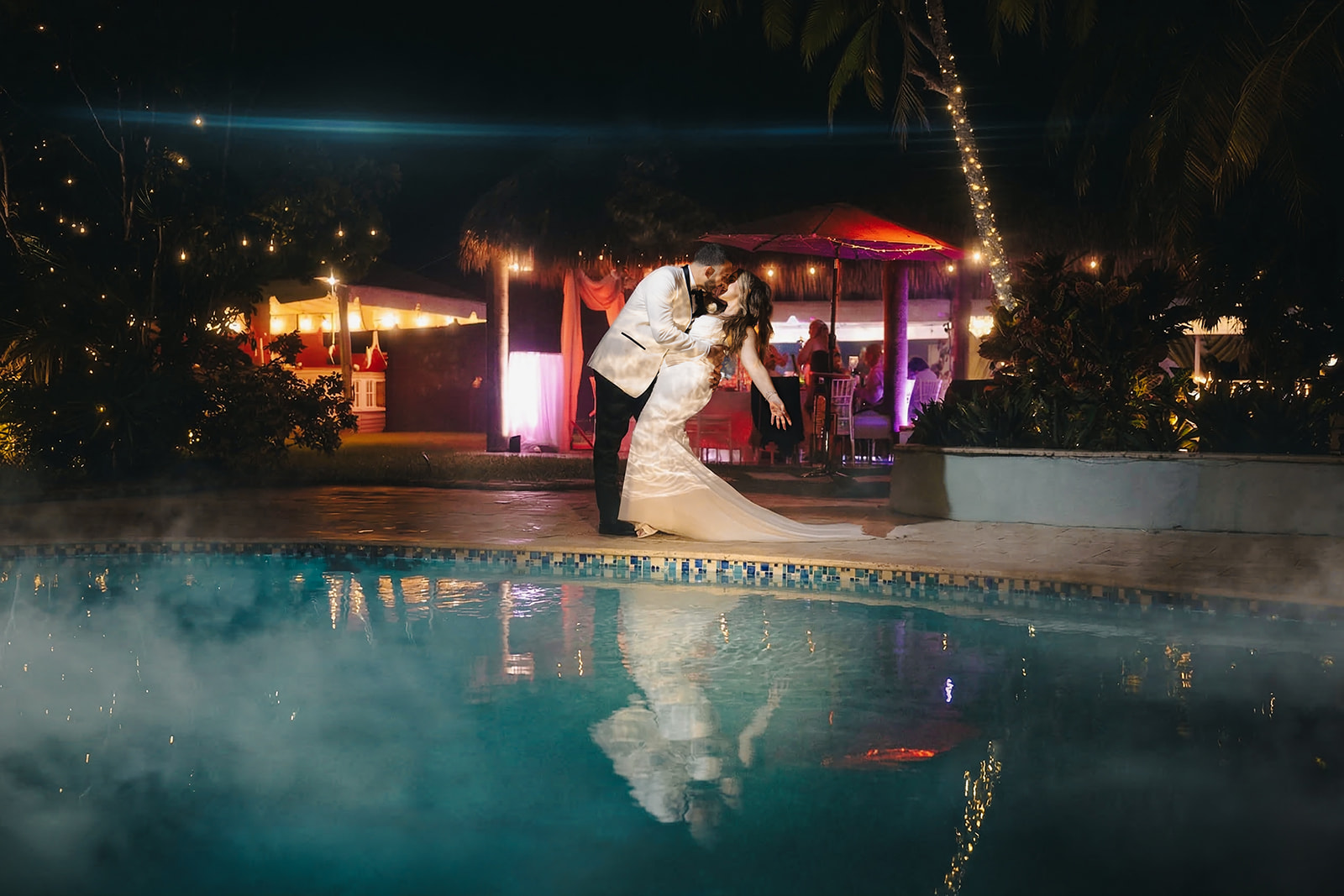 Romantic couple dipping by the pool at night