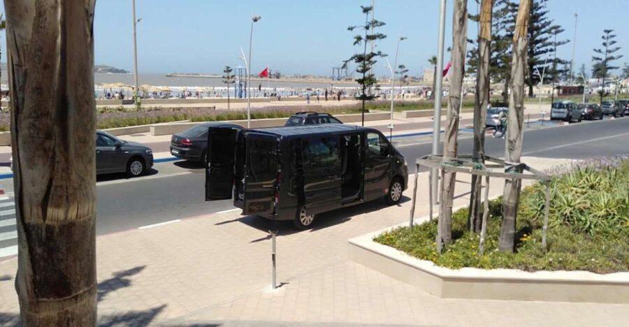 Black Mercedes van on Moroccan boulevard with palm trees