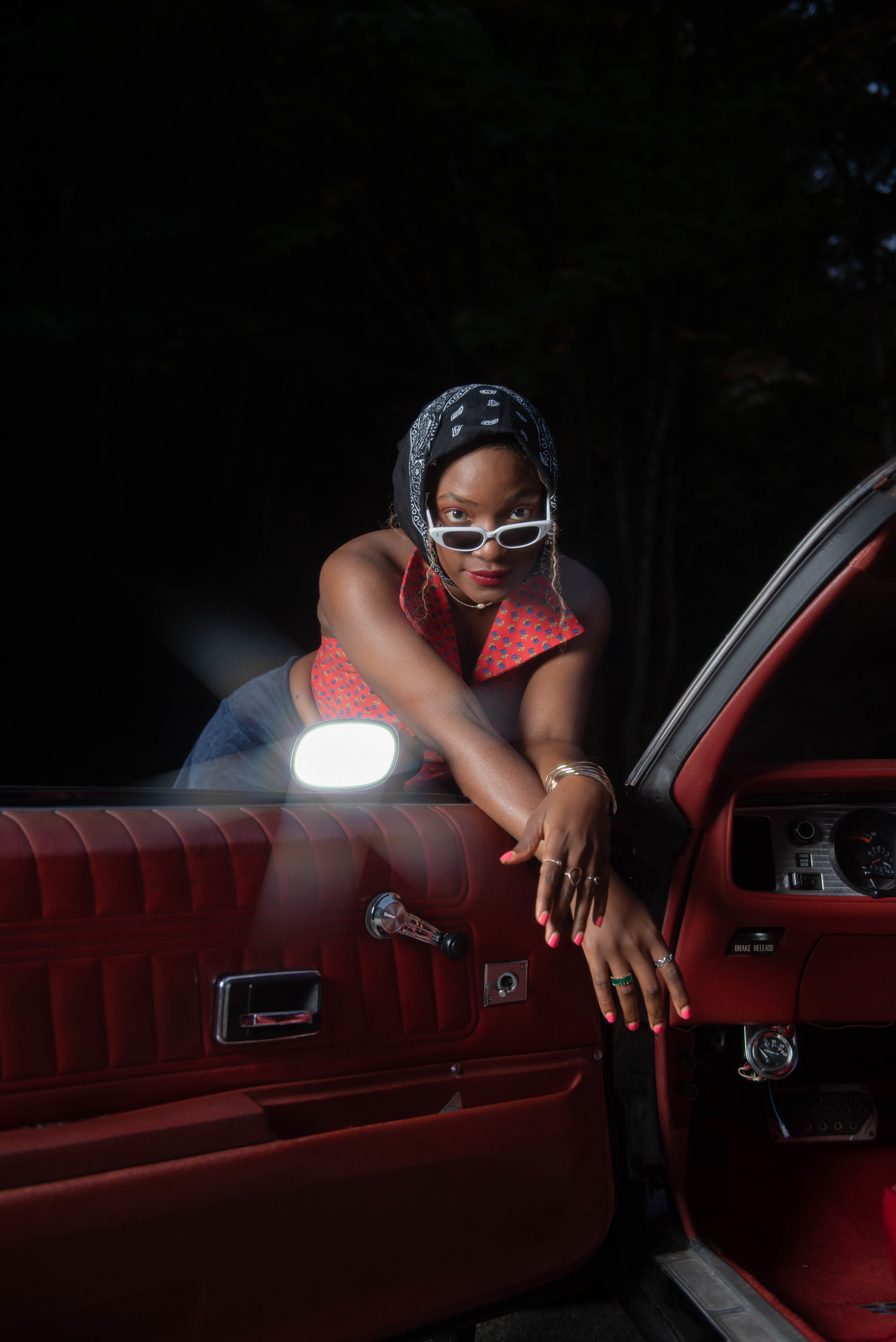 Sadé leaning on car door
