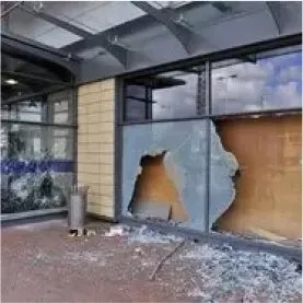 Smashed commercial storefront window demonstrating the need for security film