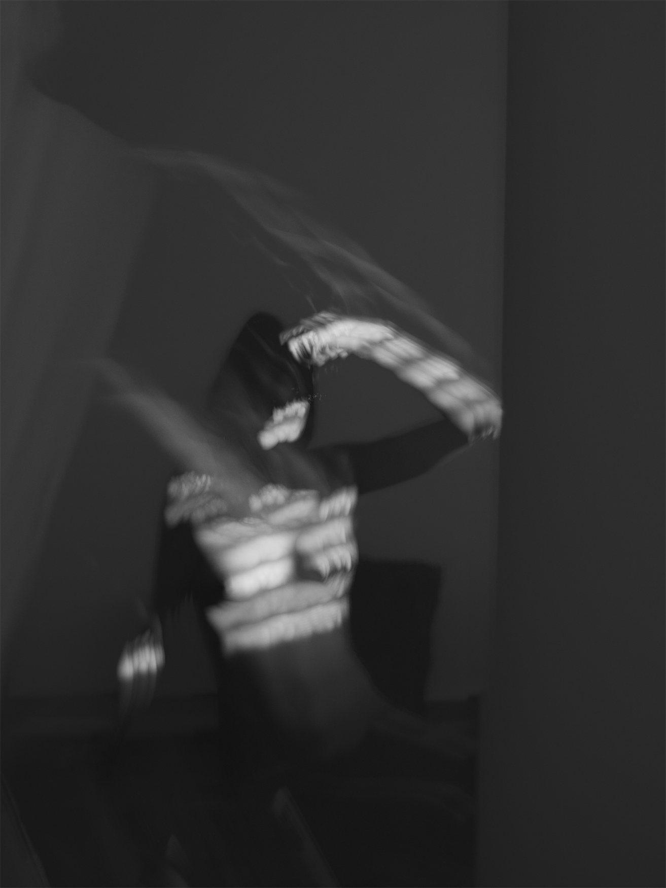 Black and white artistic self-portrait showing motion blur and abstracted form