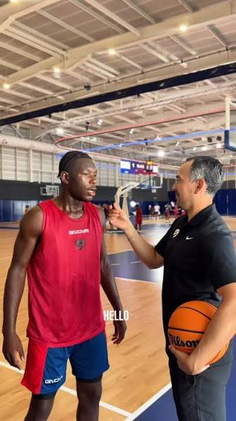 Entrenador con jugador en cancha de baloncesto