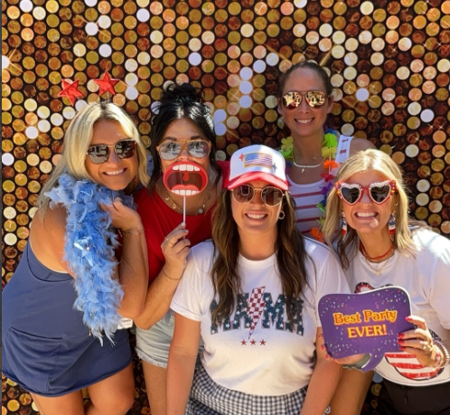 Group of women with fun props and accessories gold circle backdrop Nashville photobooth