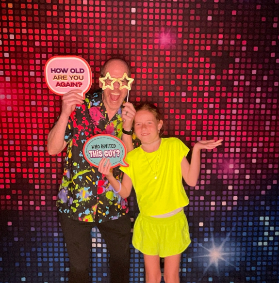 Adult and child with props at red pink pixelated light backdrop Nashville photobooth