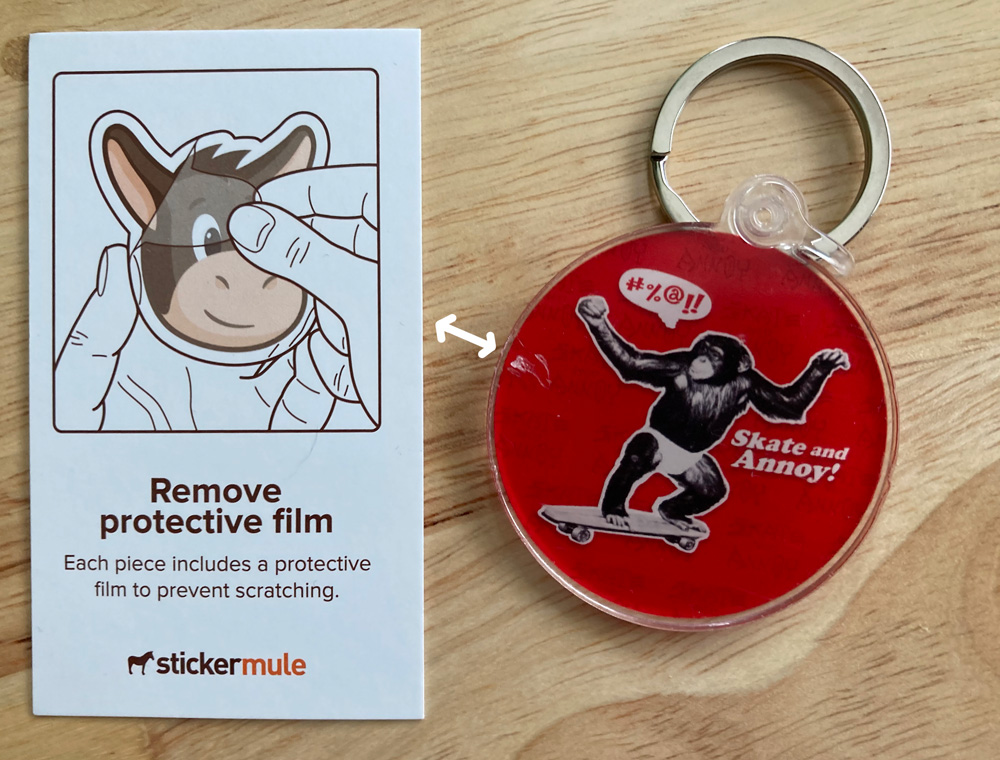 Sticker Mule acrylic keychain featuring a monkey skateboarding with protective film card