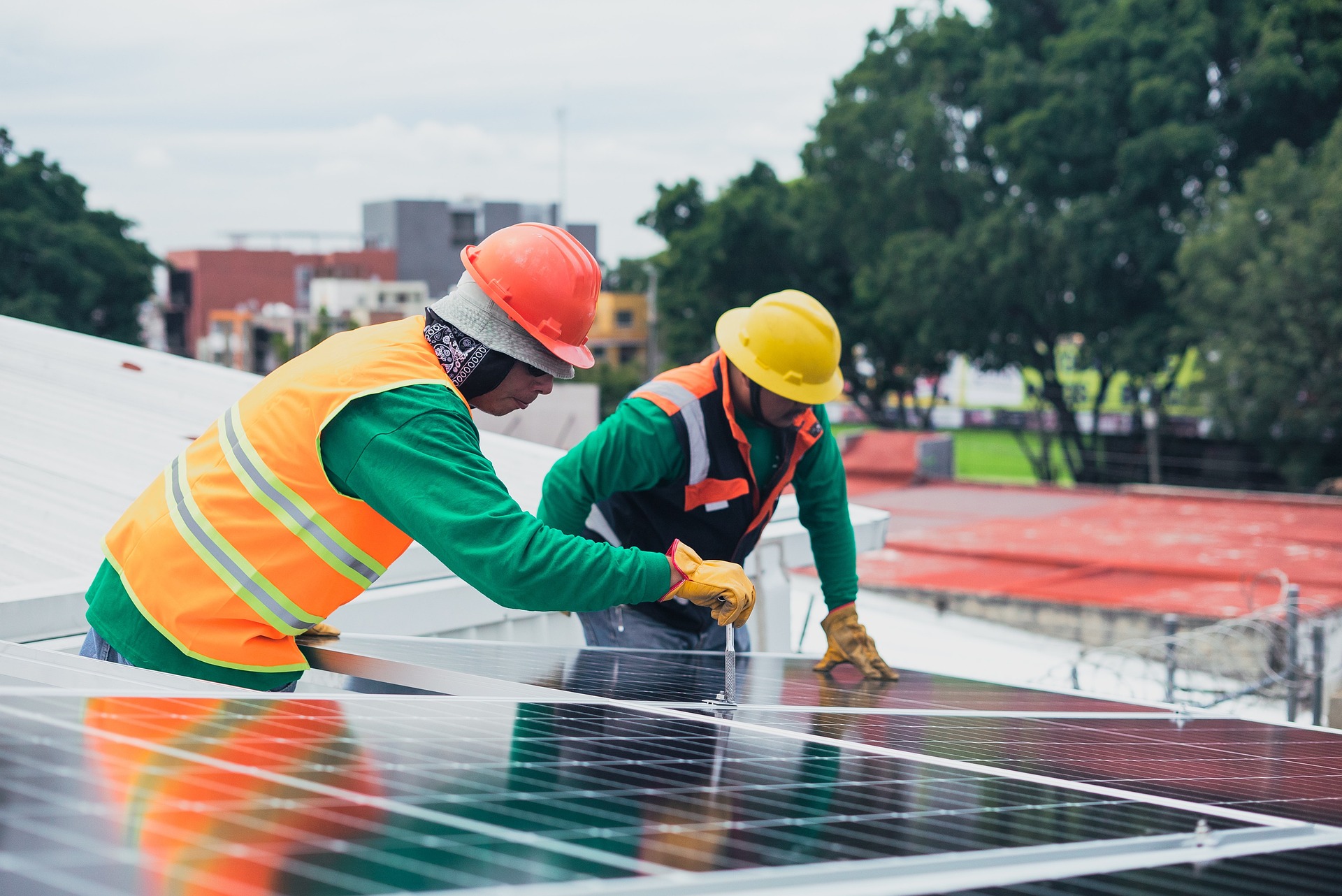 Professional solar panel installers working on rooftop installation