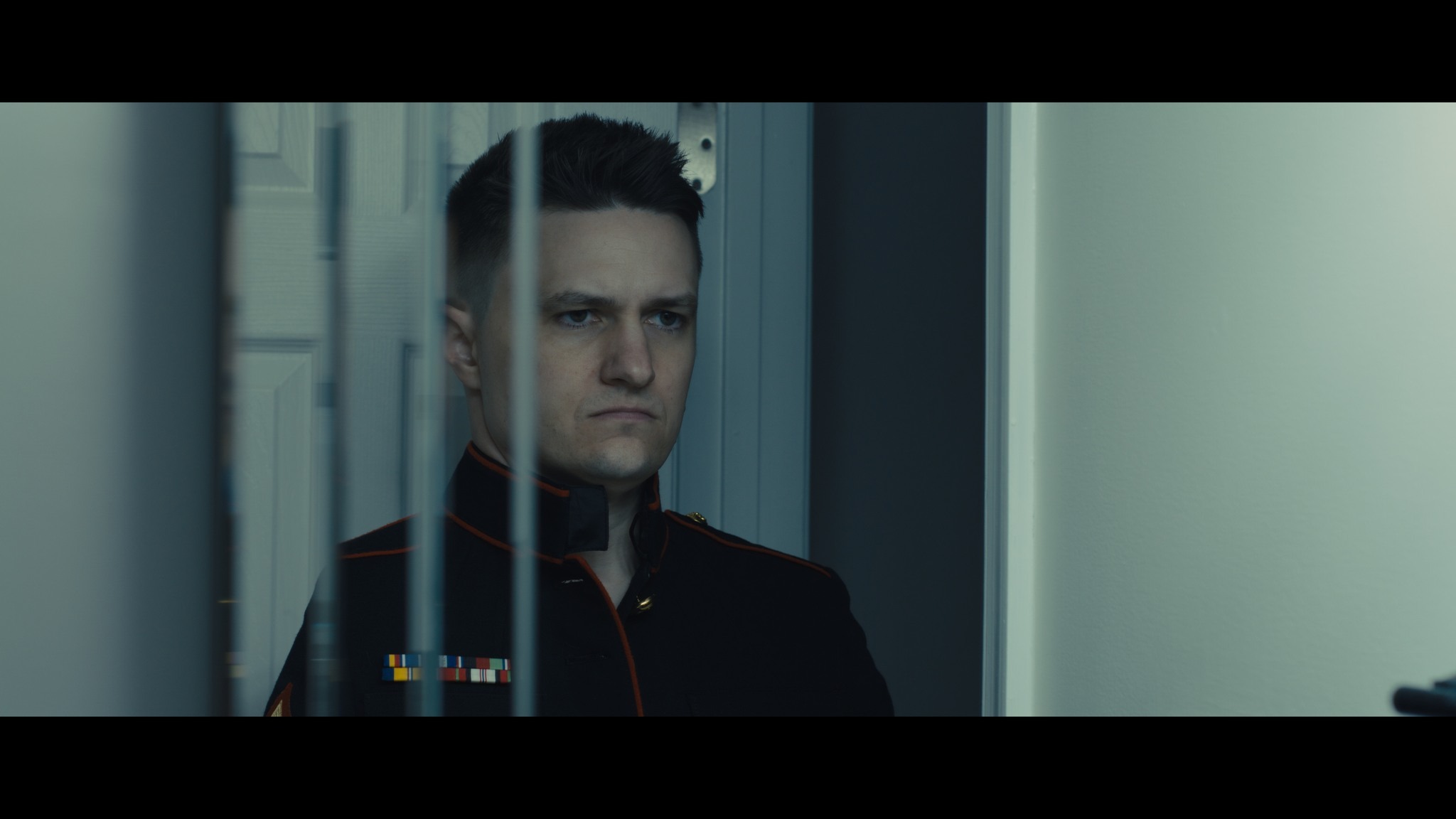 Marine in dress blues behind window
