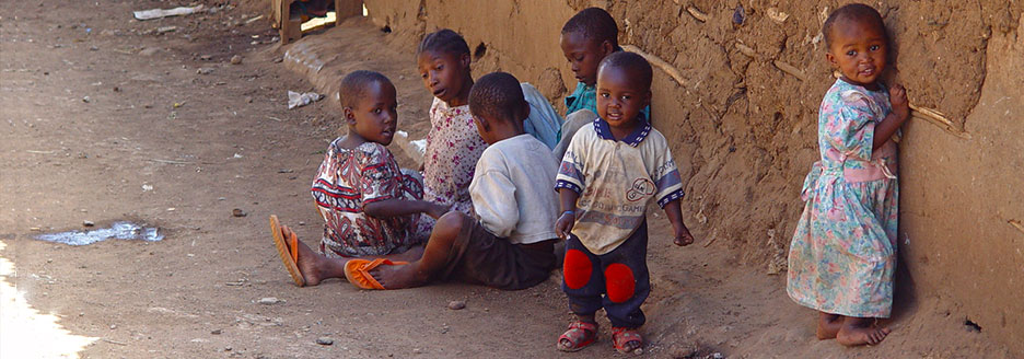 Spielende Kinder vor einer Lehmwand