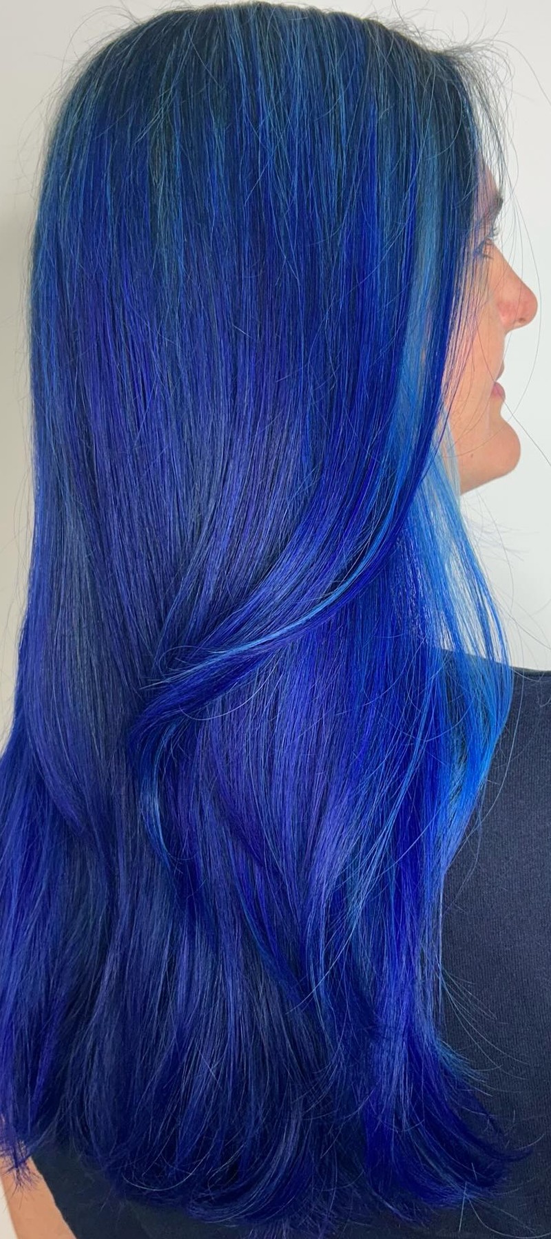 Side profile of vivid electric blue long hair
