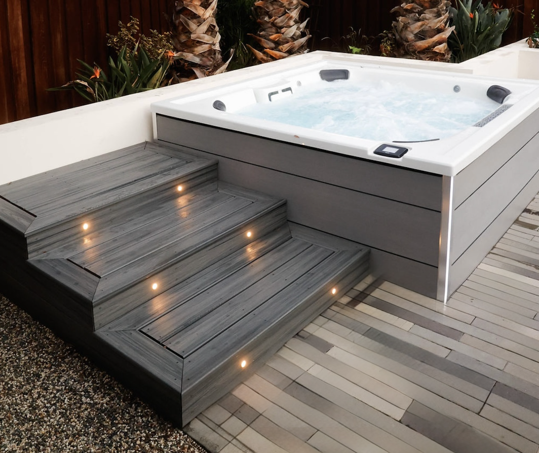 Hot tub installation with stucco planter walls and composite deck steps