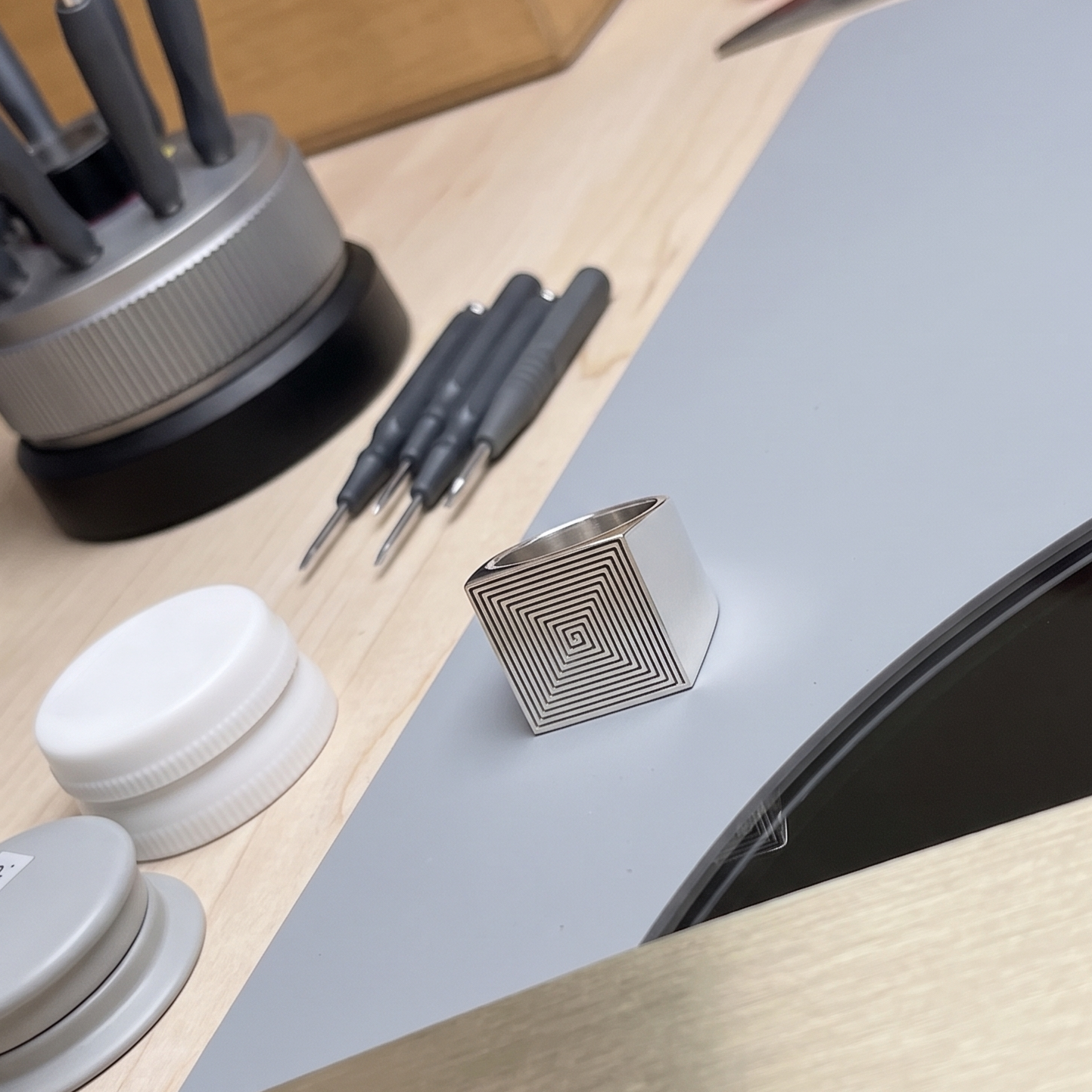 Signet 01 on a reflective studio workbench beside precision tools