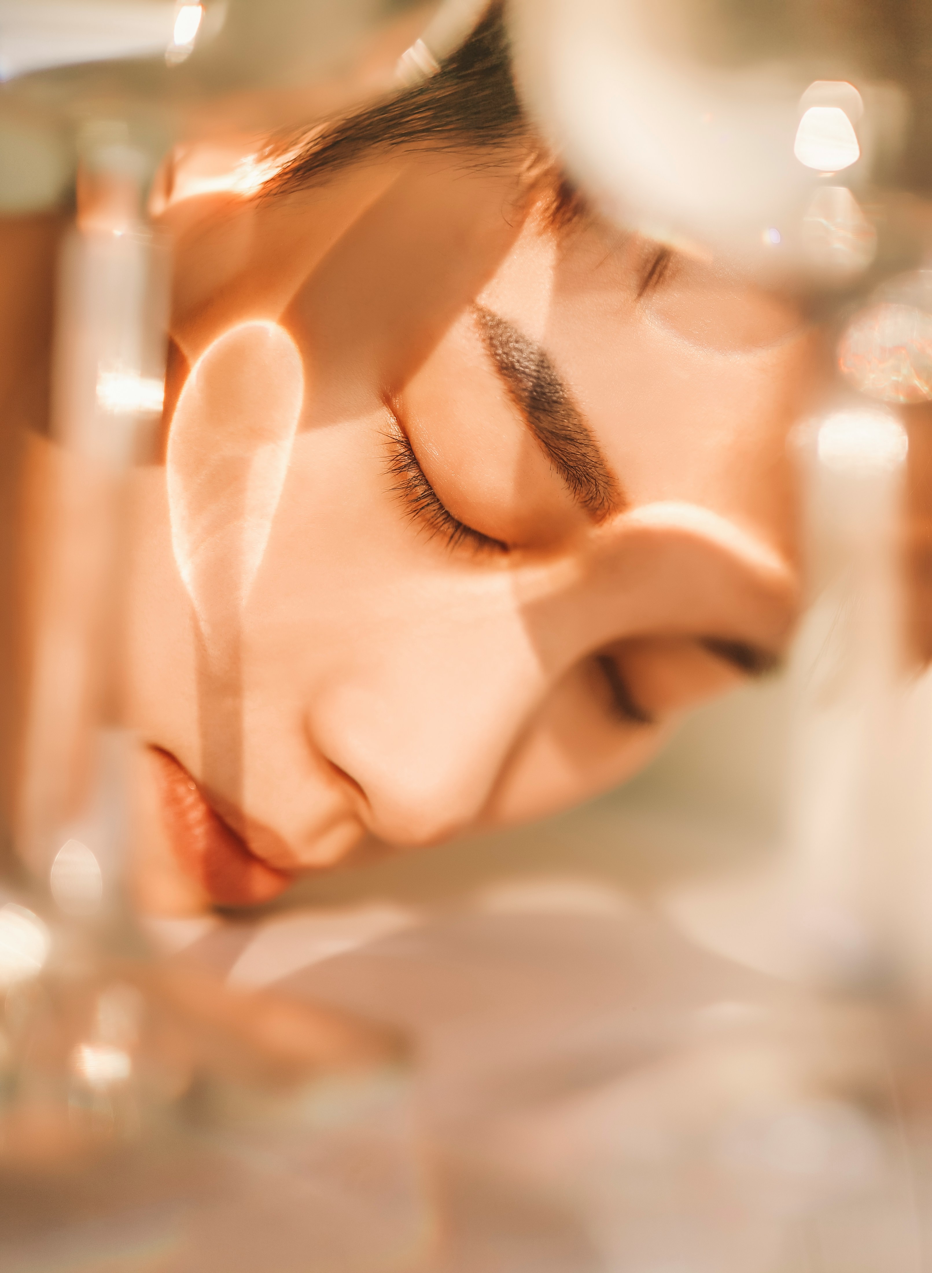 Retrato en primer plano de una mujer con piel luminosa y los ojos cerrados