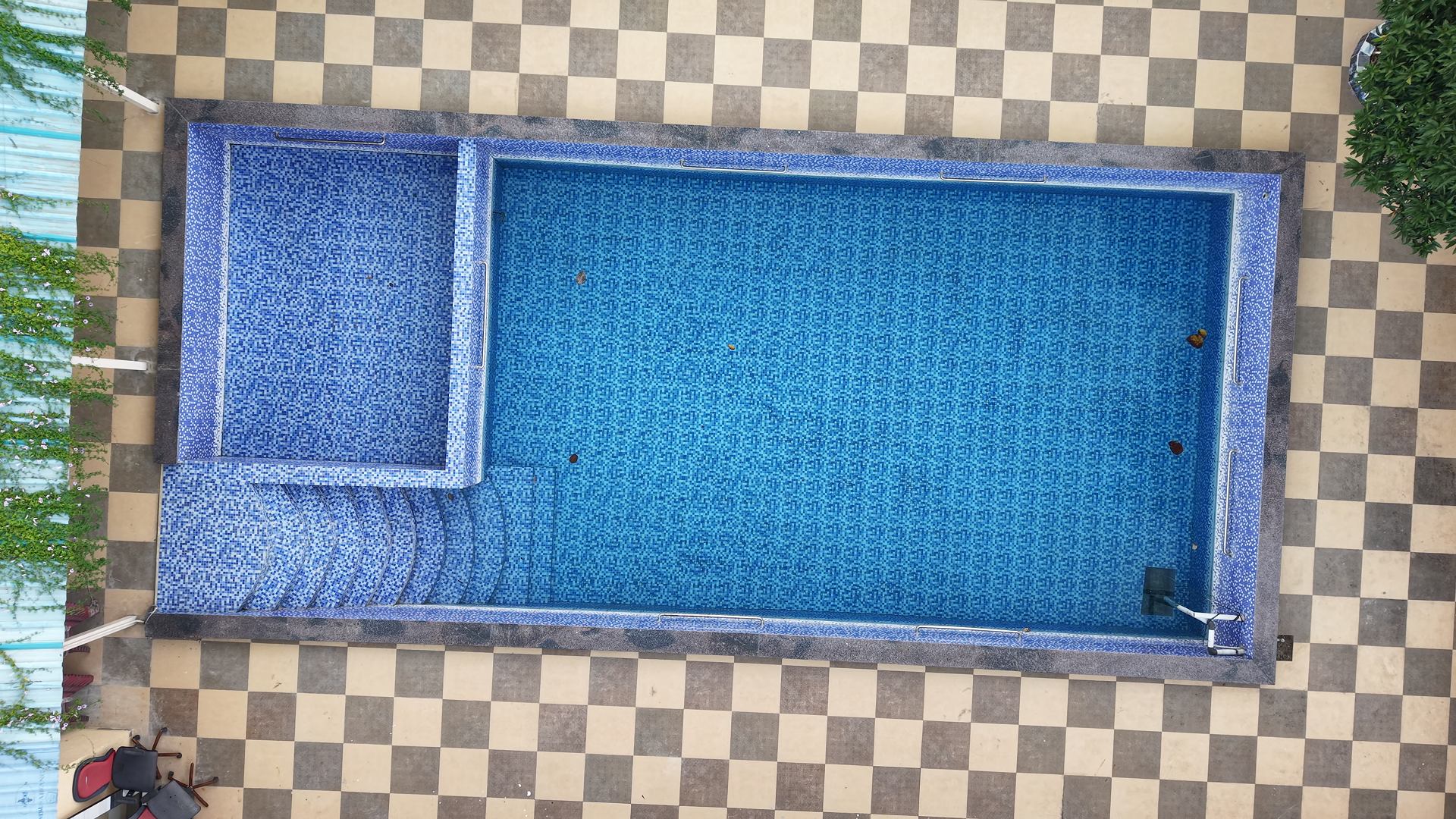 Blue-tiled swimming pool with a shallow step area.