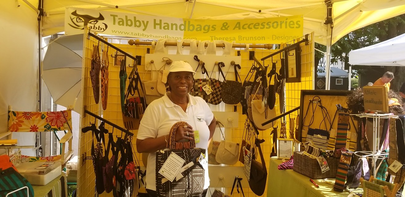 Theresa at a Tabby Handbags market booth displaying the collection