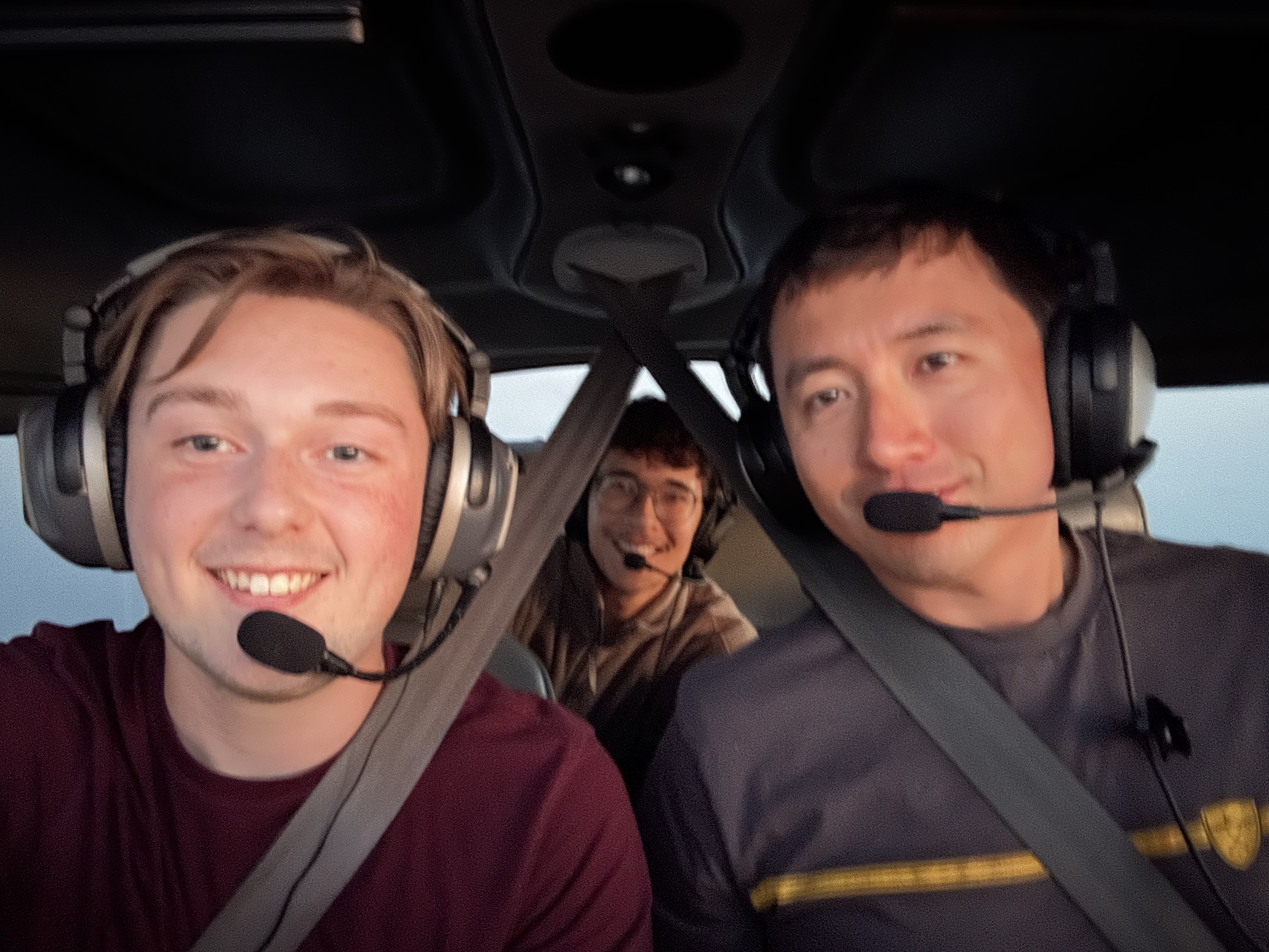 Elijah Burgess (left) and Deven Chavez (right) inside a Cessna training aircraft with a student