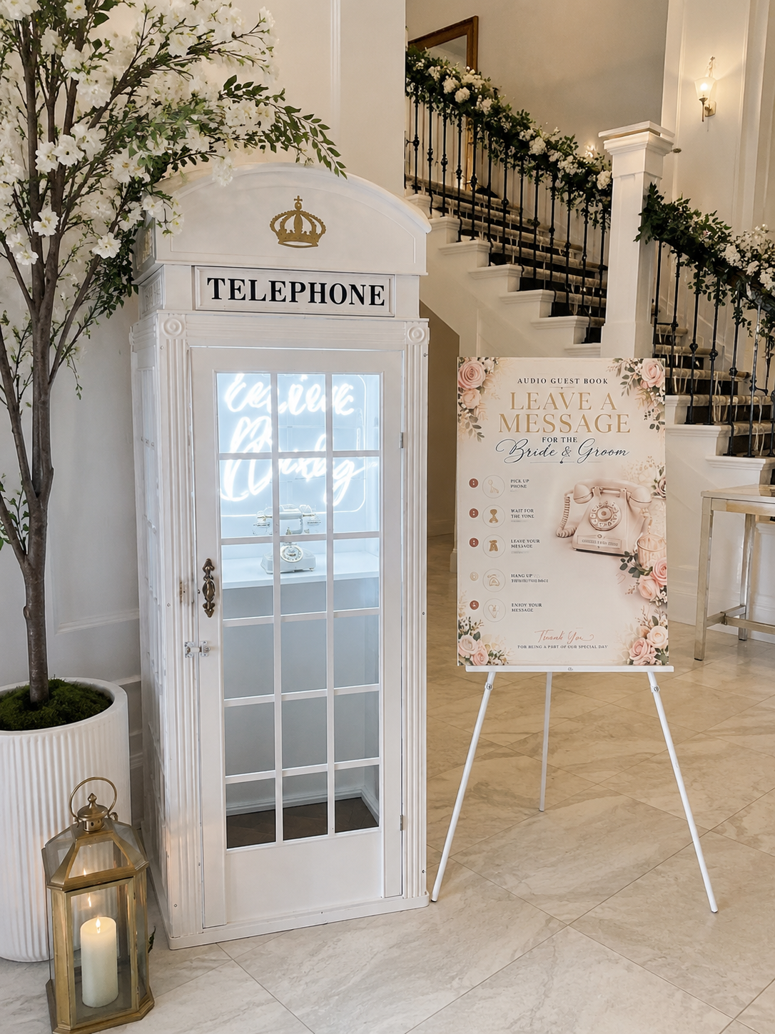 White vintage telephone box audio guest book with floral staircase and Leave a Message sign at a Hull wedding venue