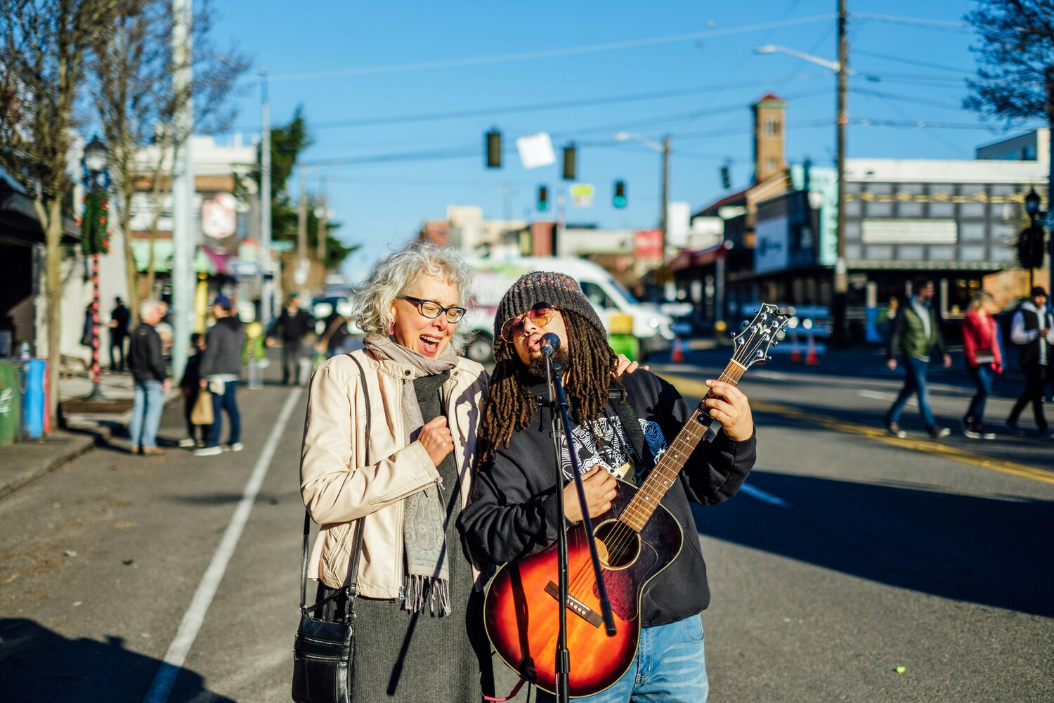 Street performer with guitar and listener