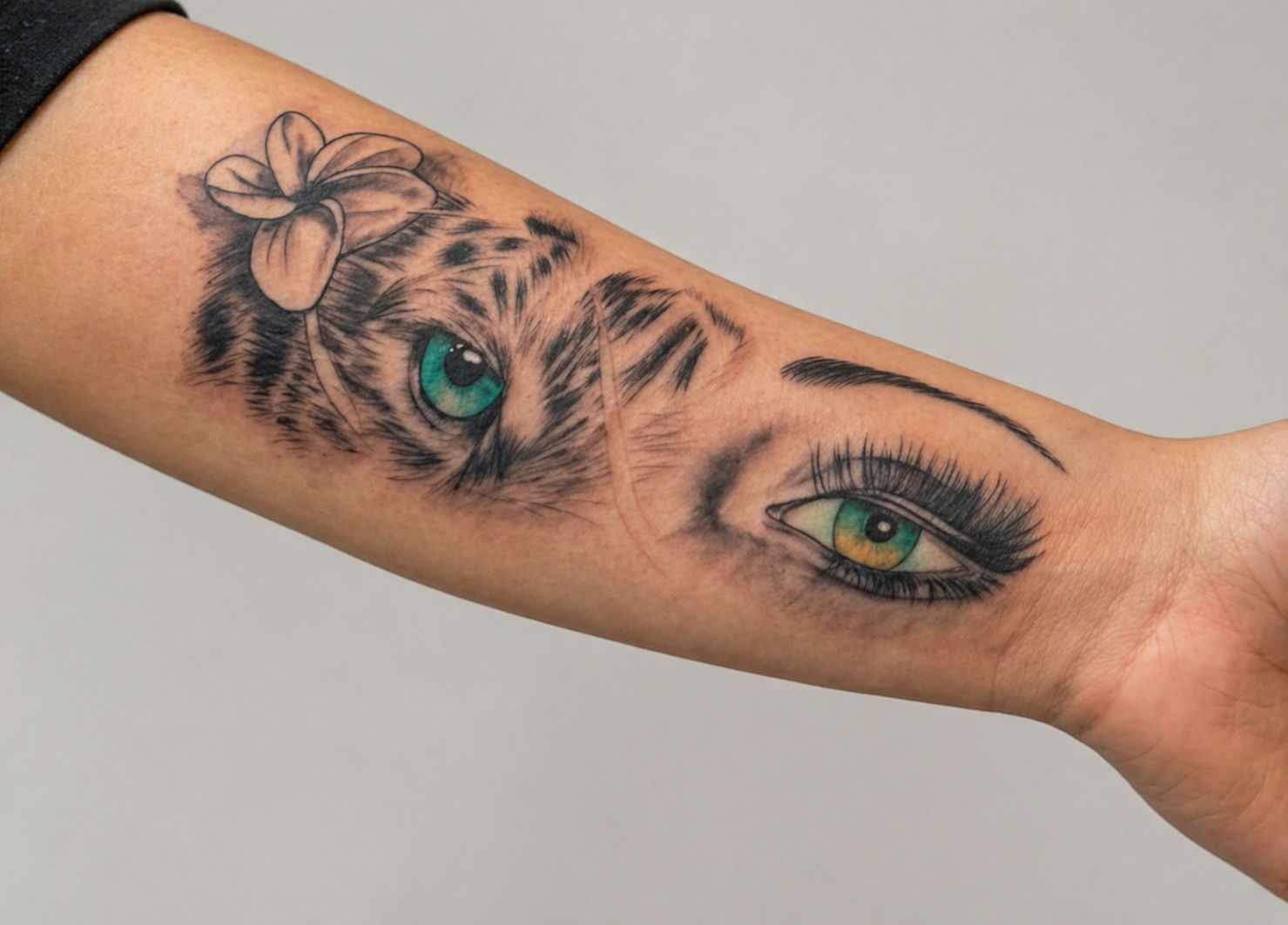 Forearm tattoo blending a snow leopard face with a hyper-realistic human eye