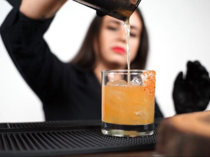 Female mixologist pouring craft cocktail - professional bartender South Florida