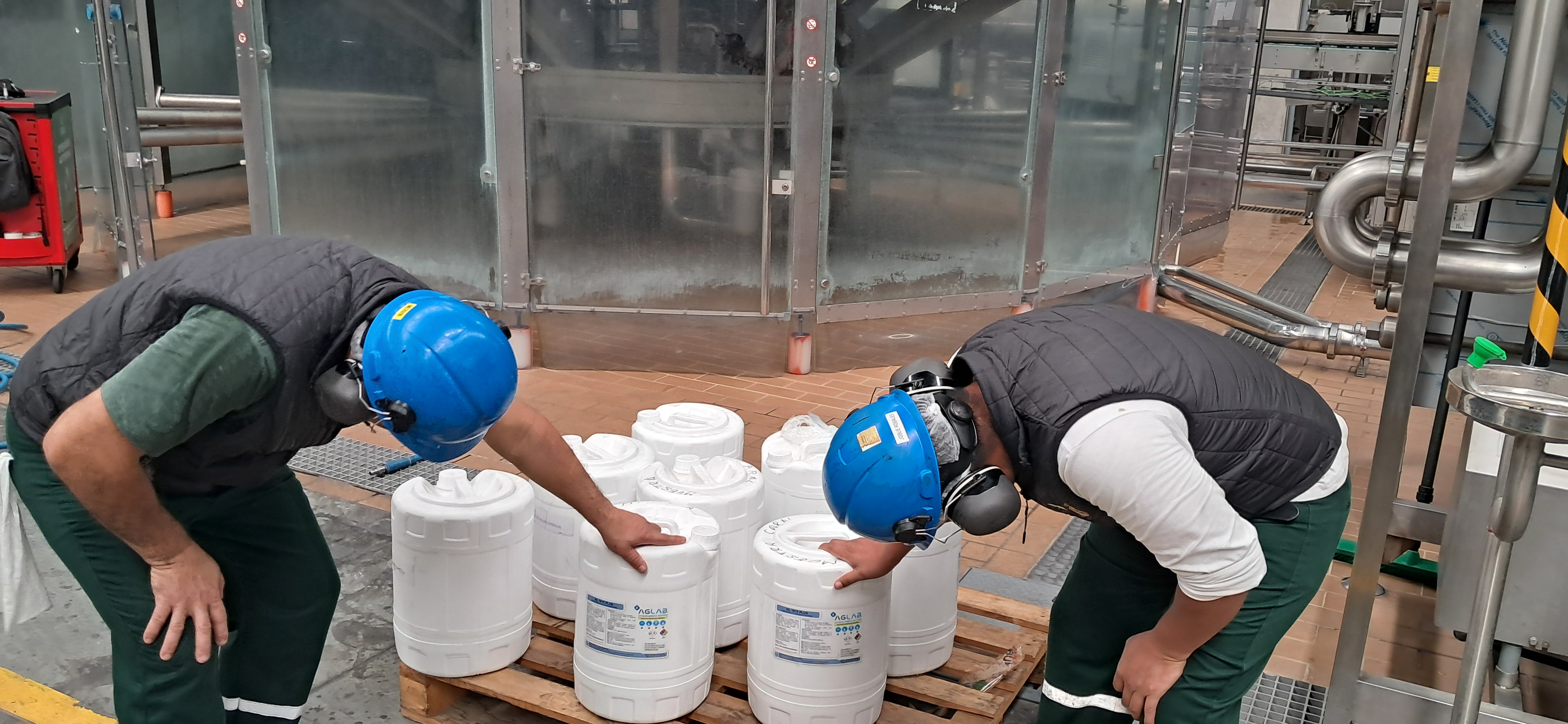 Técnicos de AGLAB realizando asistencia técnica con bidones de productos