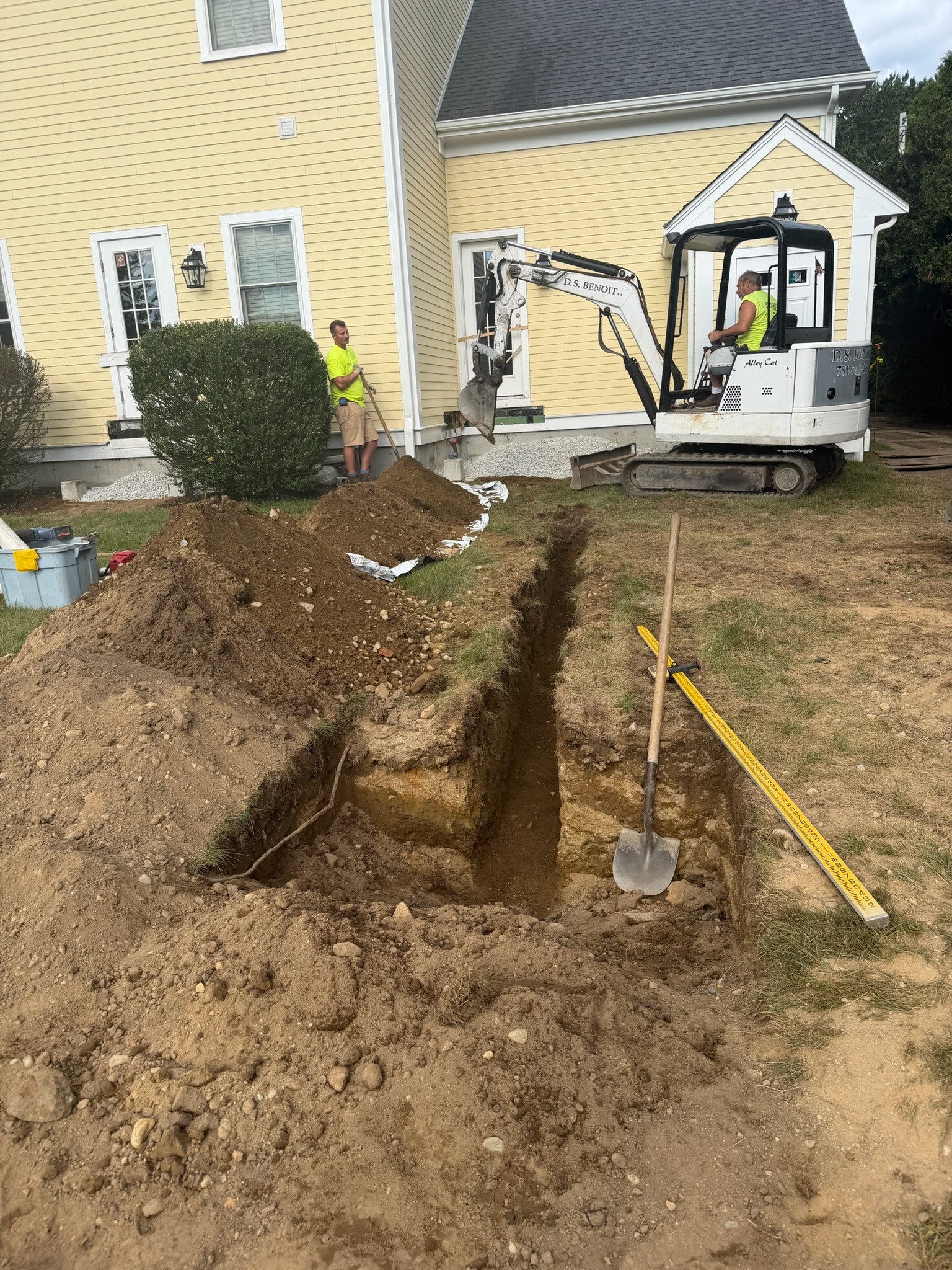 DS Benoit crew excavating a residential utility trench with compact equipment