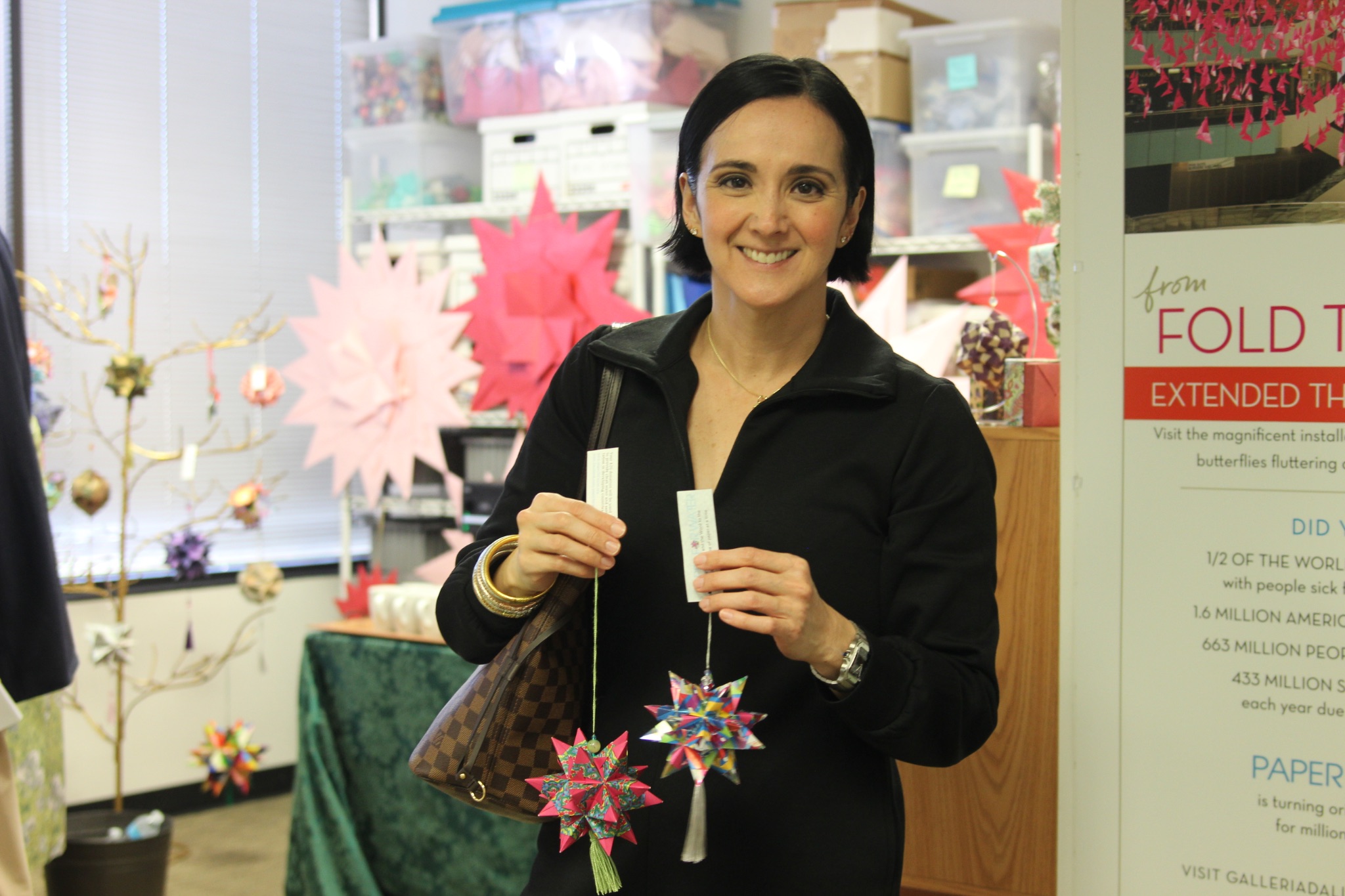 Woman proudly displaying colorful origami decorations