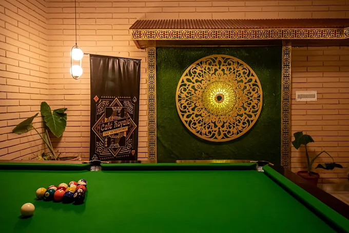 Billiards table in the Cafe Royale games room with a gold mandala wall
