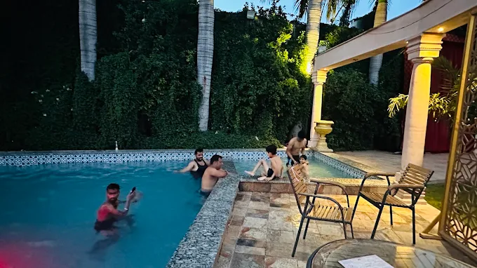 Guests enjoying the swimming pool in the evening