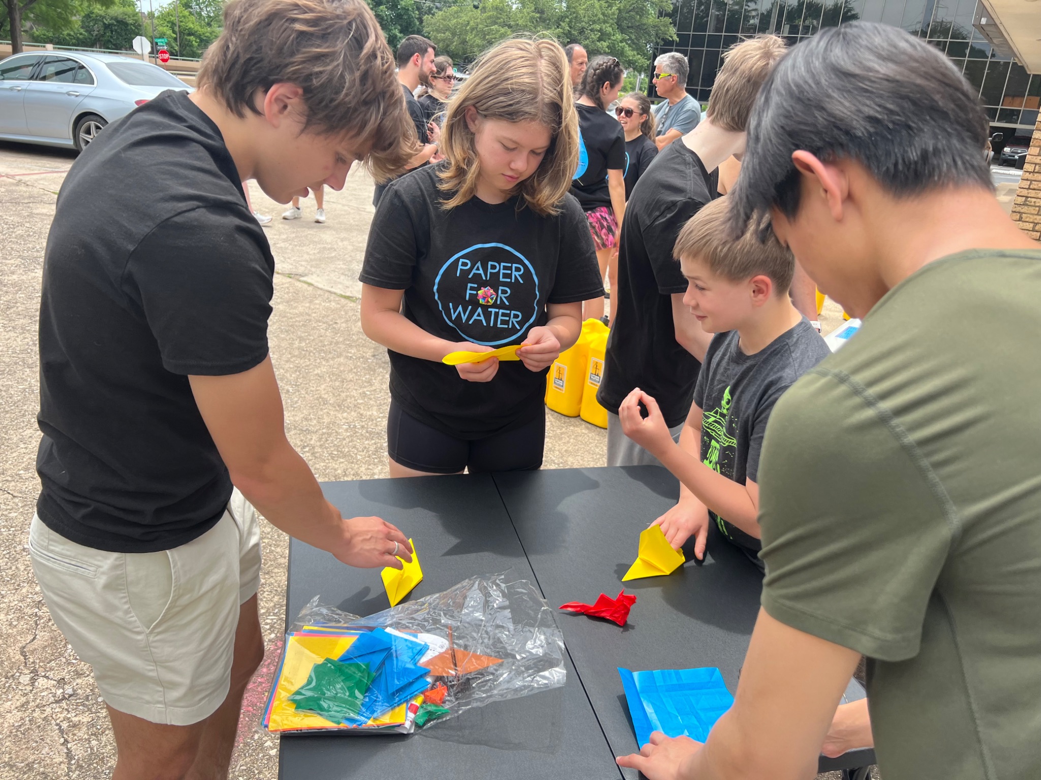 Diverse youth volunteers folding colorful origami together