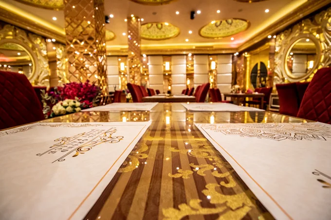 Gold-toned restaurant interior with mirrored walls and velvet chairs