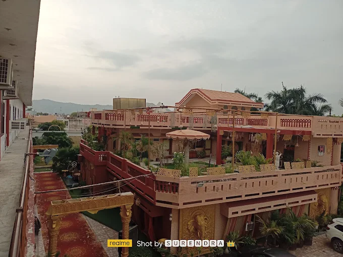Palace-style hotel building and terraces with hills in the distance