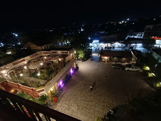 Night view of the hotel courtyard and decorated terrace glowing with lights