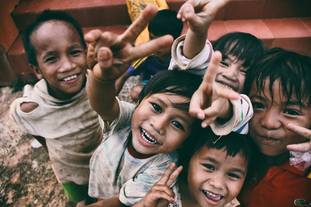 Joyful children reaching toward the camera with peace signs