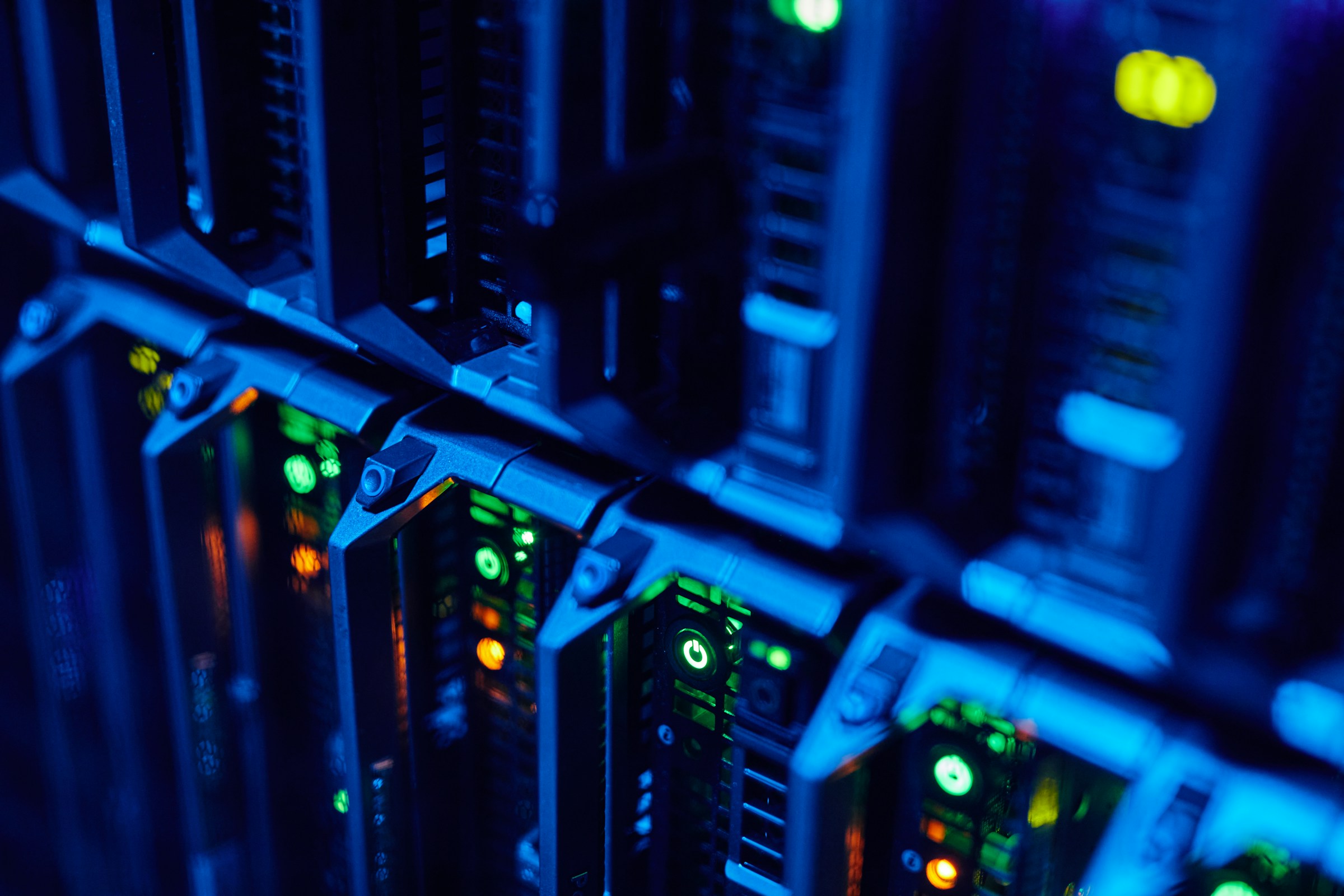 Close-up of server racks with blue lighting and green LED indicators