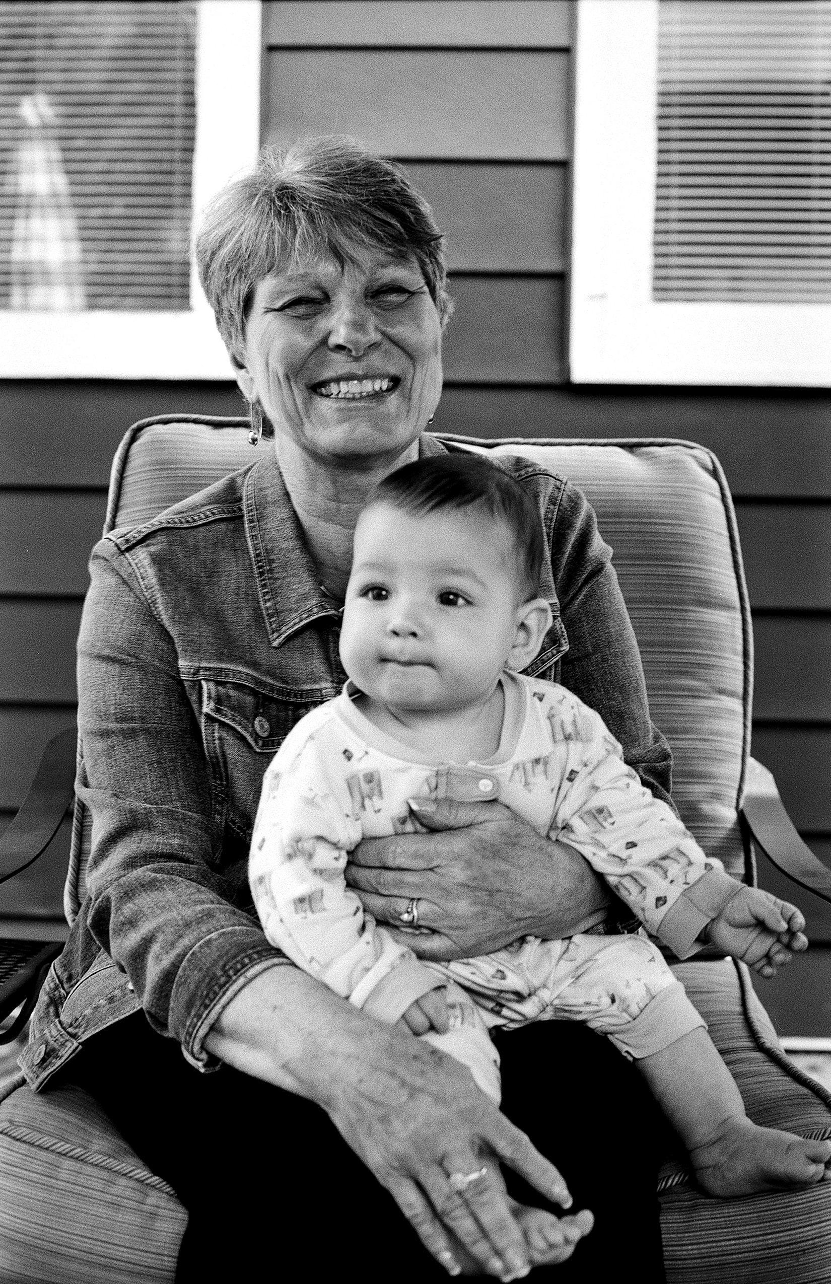 Smiling mother with young child sitting together on upholstered chair