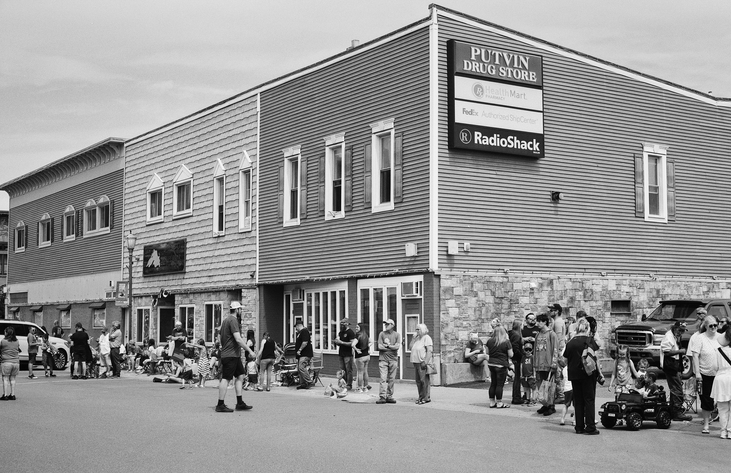 Putvin Drug Store building with crowd gathered outside during community event