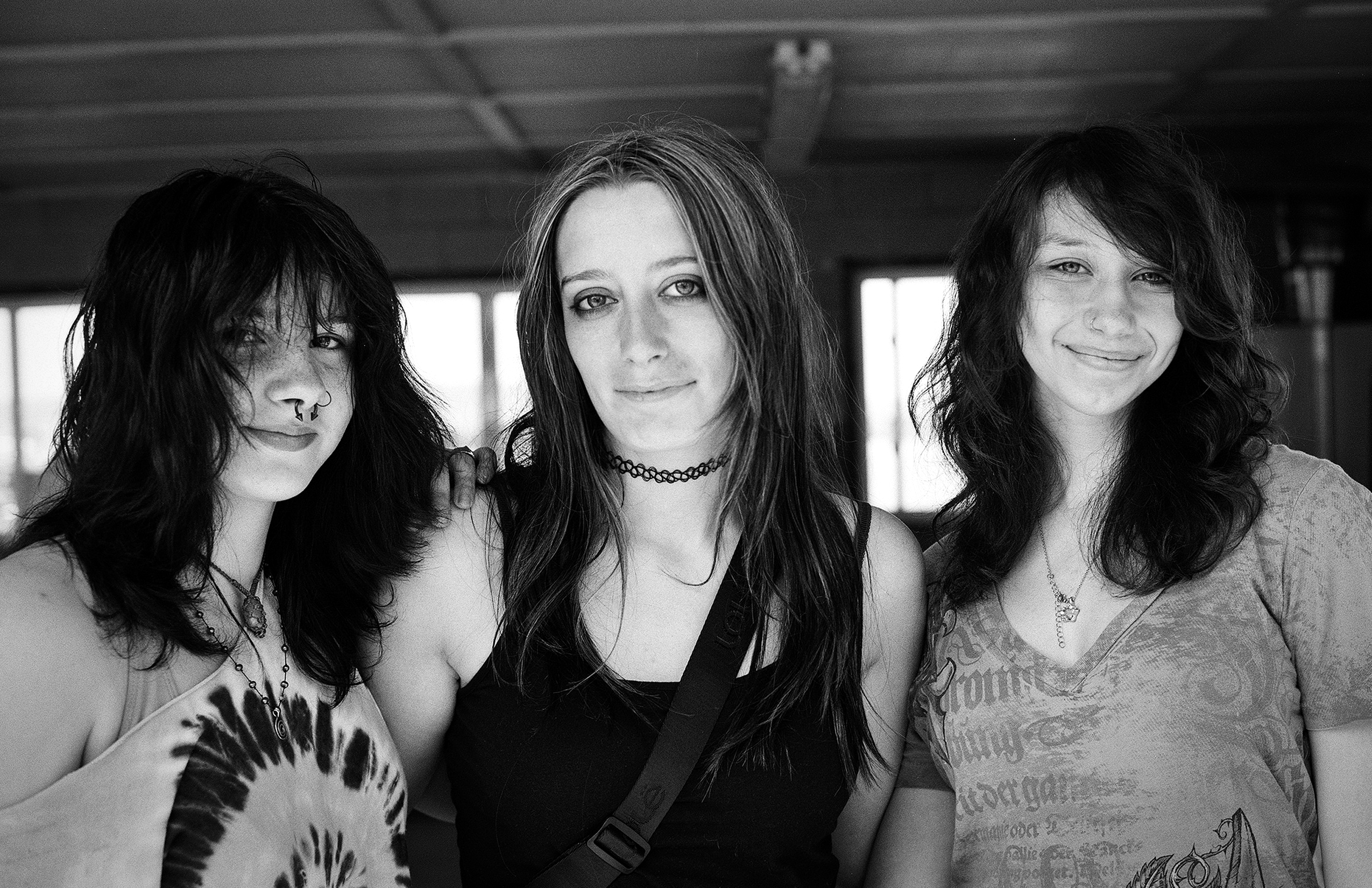 Group portrait of three women with long dark hair indoors