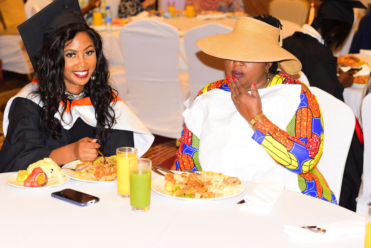 Female graduate with proud mother at graduation banquet