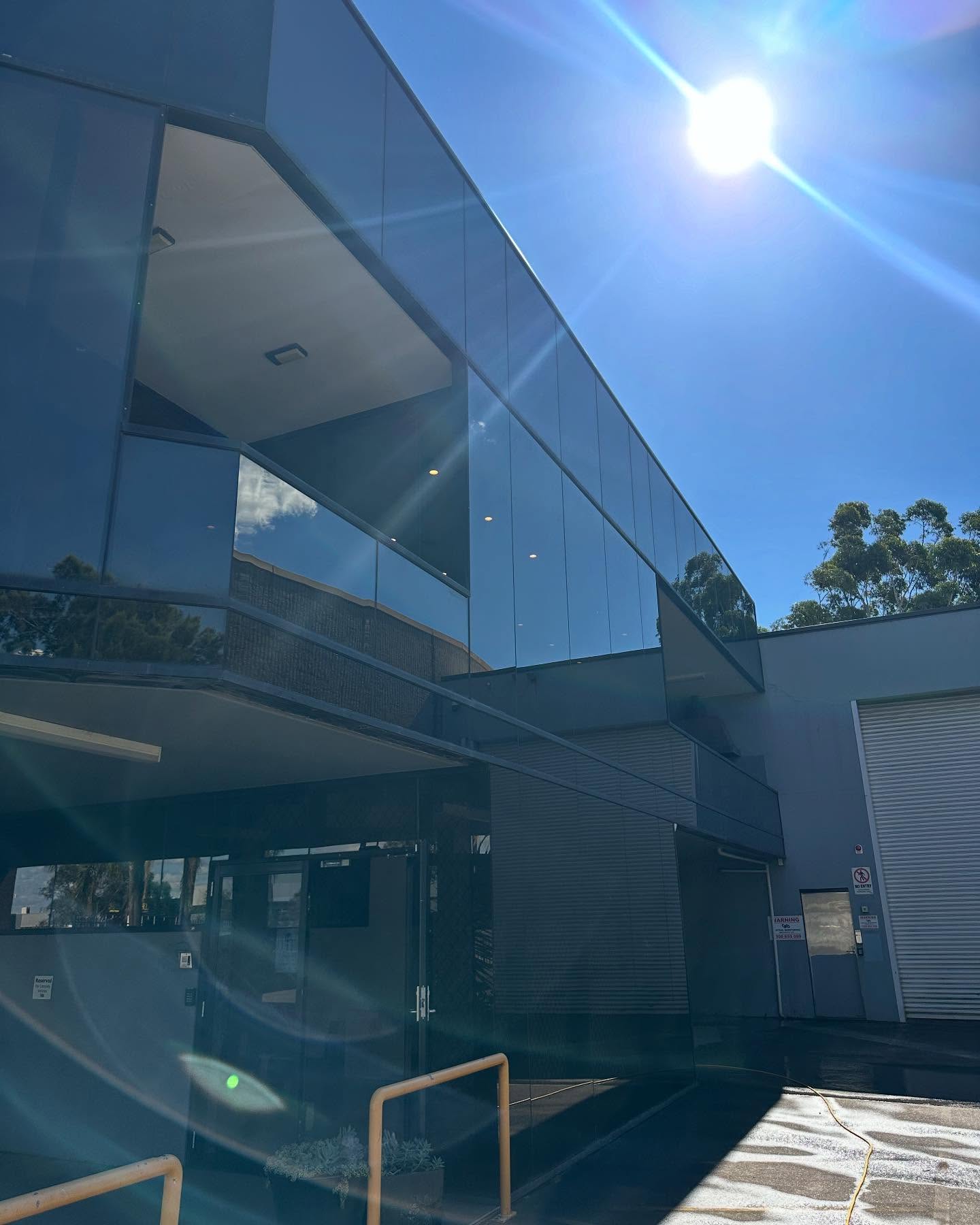 Commercial building exterior glass cleaning with sun reflection